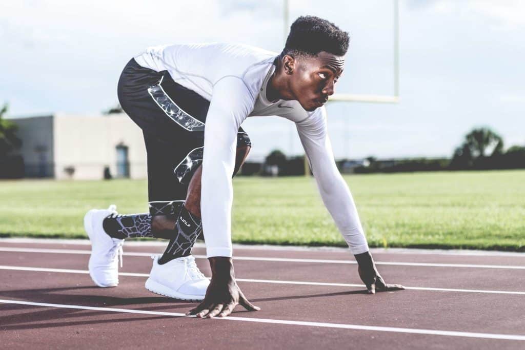 man-wearing-white-sweater-and-black-shorts-about-to-run-936094