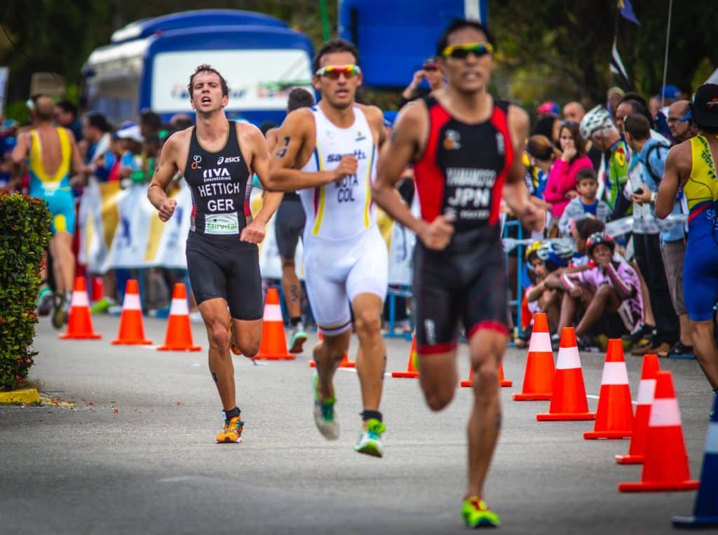 determined professional athletes running on track in stadium