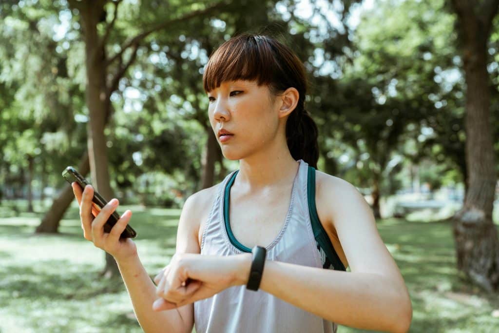 Concentrated young asian woman using smartphone in park
